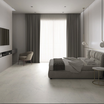 Un dormitorio moderno cuenta con una cama baja tapizada ubicada cerca de cortinas del piso al techo. Una silla minimalista y mes