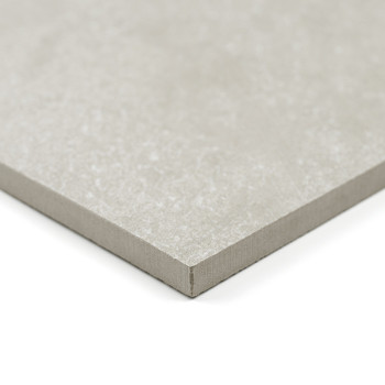 Un azulejo cuadrado de color gris claro con una textura suave descansa sobre un fondo blanco, mostrando sus bordes finos y recto