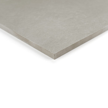 Un azulejo cuadrado de color gris claro yace plano, mostrando una superficie lisa y bordes afilados. se apoya sobre un fondo bla