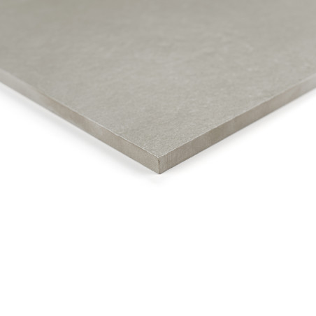 Un azulejo cuadrado de color gris claro yace plano, mostrando una superficie lisa y bordes afilados. se apoya sobre un fondo bla