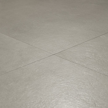 azulejos de cerámica gris colocadas planas con una superficie texturizada sutil, que se cruzan con líneas de lechada formando un