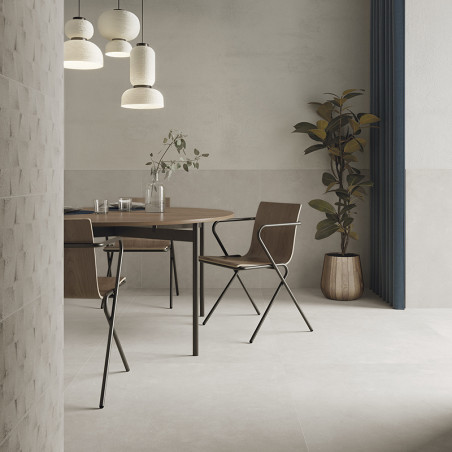 Una mesa de comedor de madera con cristalería y plantas se encuentra bajo luces colgantes, rodeada de sillas modernas en una hab
