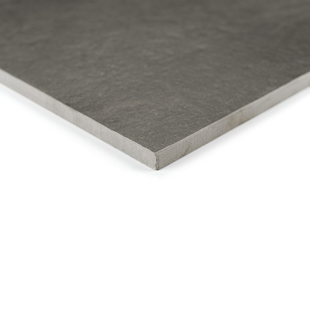 Un azulejo cerámico rectangular oscura descansa plana sobre un fondo blanco, mostrando una superficie texturizada y bordes lisos