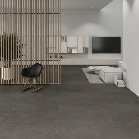 Los azulejos de color gris oscuro cubren un espacio habitable moderno y separan una elegante sala de estar con una silla negra y