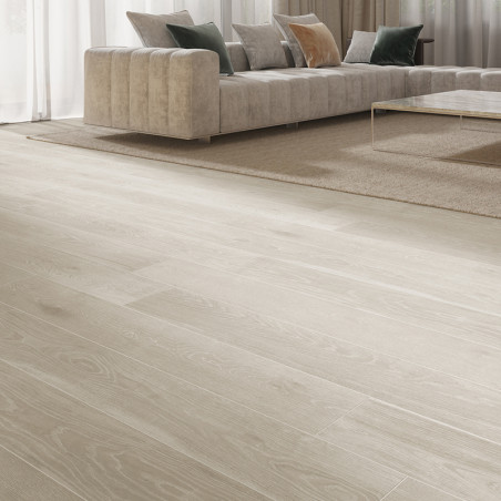 Los pisos de madera se extienden a lo largo de una moderna sala de estar y conducen a un lujoso sofá seccional y una mesa de cen