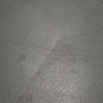 Um piso cinza fosco fica plano, cortado por linhas sutis de argamassa, criando uma superfície lisa e uniforme em um ambiente min