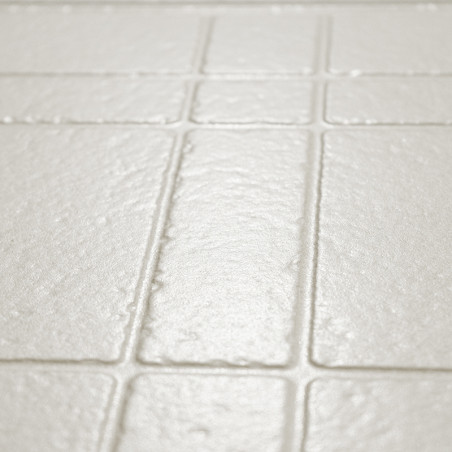 Los azulejos rectangulares de color beige claro texturizados están dispuestos en un patrón de cuadrícula, creando una superficie