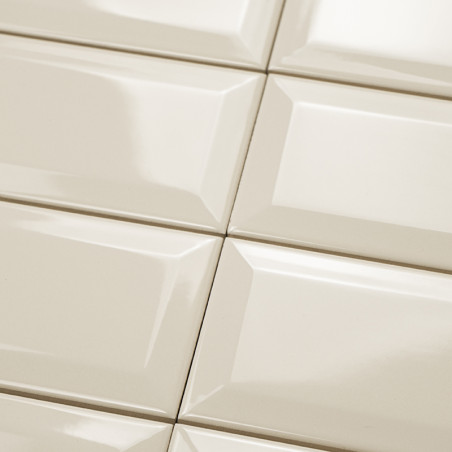 Keramische tegels gerangschikt in een rasterpatroon, reflecterend licht en creëren een glanzend oppervlak in een binnenomgeving.