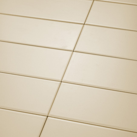 Los azulejos rectangulares de color crema están cuidadosamente dispuestos en un patrón de cuadrícula diagonal. La superficie lis