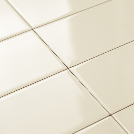 Les carreaux de céramique de couleur crème sont disposés selon un motif en grille, réfléchissant doucement la lumière sur un sol