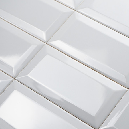 White rectangular tiles arranged in a grid, featuring a glossy, beveled surface that reflects light in a uniform pattern.