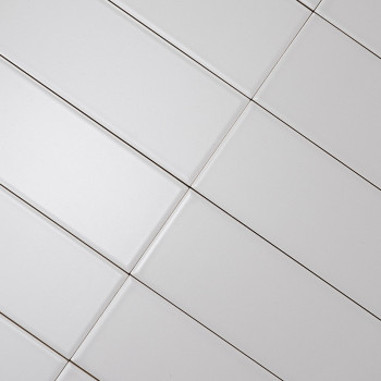 azulejos rectangulares blancas alineadas en diagonal, creando un patrón de cuadrícula. Líneas de lechada oscuras separan Los azu
