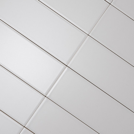 azulejos rectangulares blancas alineadas en diagonal, creando un patrón de cuadrícula. Líneas de lechada oscuras separan Los azu