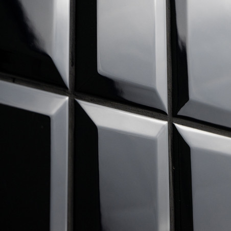 Los azulejos negros brillantes reflejan la luz, creando un efecto de espejo brillante. Están dispuestos en forma de cuadrado con