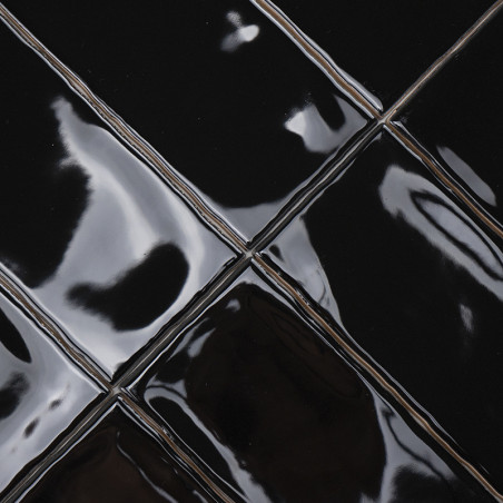 Los azulejos de cerámica de color negro brillante reflejan la luz, creando una apariencia elegante en un patrón de cuadrícula. E
