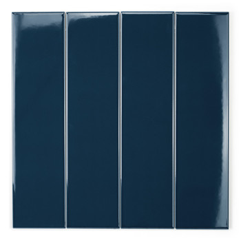 Un azulejo rectangular de color azul marino brillante se alza verticalmente sobre un fondo blanco y refleja la luz en el borde s