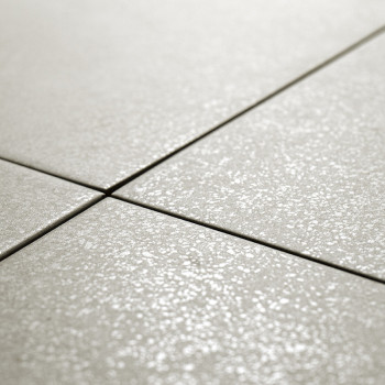 Les carreaux de céramique, disposés selon un quadrillage, sont alignés sur une surface plane. Les carreaux ont une finition subt