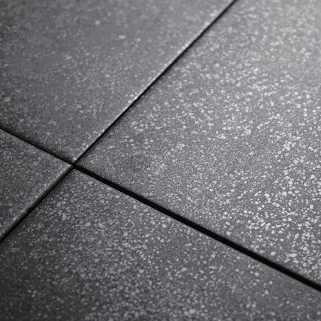 Quatre carreaux gris foncé présentent une subtile texture mouchetée. Ils sont étroitement alignés, formant un motif de grille so