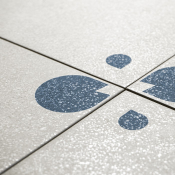 Gray ceramic tiles feature blue abstract shapes resembling droplets, arranged in a pattern across four tile junctions, on a text