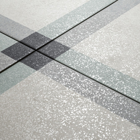 Una superficie de mosaico texturizada muestra bandas translúcidas superpuestas que forman un patrón cruzado. El fondo es gris cl
