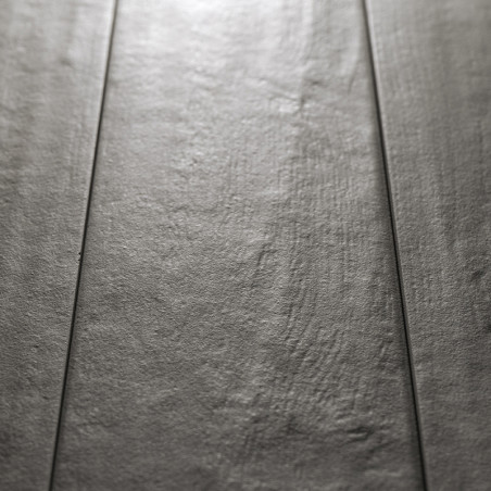 Les carreaux rectangulaires gris sont plats avec une surface texturée subtile, réfléchissant la lumière, ressemblant à un motif 