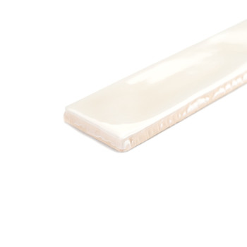 Un azulejo cerámico rectangular de color blanco brillante descansa sobre una superficie blanca lisa, resaltando su textura suave