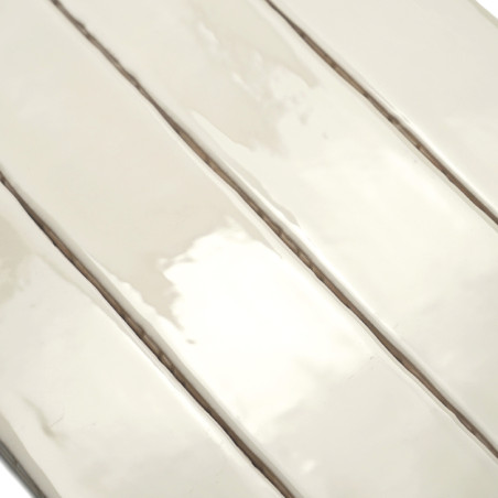 azulejos rectangulares brillantes de color crema alineadas verticalmente, creando una superficie lisa y reflectante con sutiles 