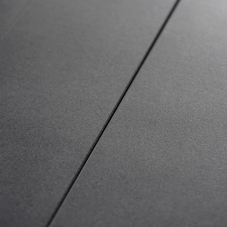 Un azulejo liso de color gris oscuro, plano, linda con otro azulejo idéntico, separado por una línea de lechada estrecha y recta