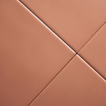 Quatre carreaux de couleur terre cuite disposés en diagonale, se croisant au centre, créant un motif géométrique homogène dans u