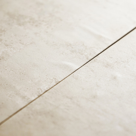 Dois ladrilhos bege formam uma costura reta, apresentando uma superfície levemente texturizada, sugerindo um piso ou design de p