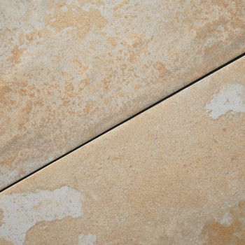 Les carreaux de céramique disposés en diagonale présentent une couleur beige clair avec des taches subtiles et texturées. Les ca
