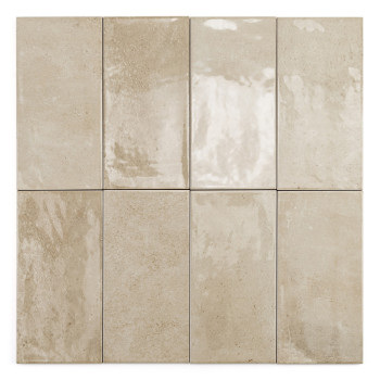 Un azulejo beige rectangular con un acabado liso y brillante se encuentra sobre un fondo blanco liso.
