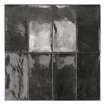 Azulejo rectangular negro brillante, que refleja la luz, centrado en un fondo blanco liso.