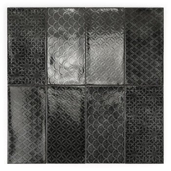 El azulejo rectangular presenta una superficie brillante de color gris oscuro con un patrón geométrico repetitivo de diamantes. 