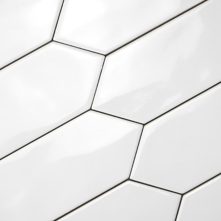 Ladrilhos hexagonais alongados brancos são instalados em um padrão escalonado, criando uma superfície elegante e moderna com bor