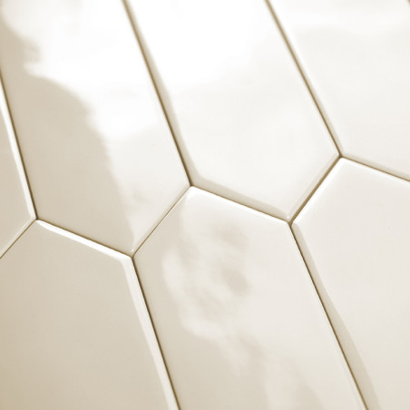 Ladrilhos hexagonais alongados, brancos e brilhantes são alinhados em um padrão escalonado, refletindo a luz, criando uma superf