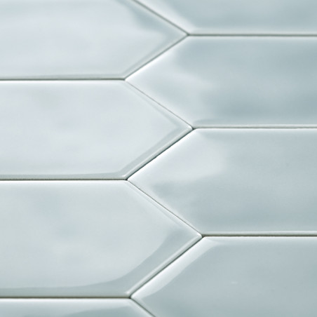 Les carreaux hexagonaux créent un motif en mosaïque, réfléchissant doucement la lumière. La surface lisse et brillante contribue