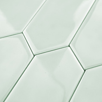 Ladrilhos hexagonais se encaixam perfeitamente, criando um padrão contínuo. Eles apresentam um acabamento verde menta brilhante,