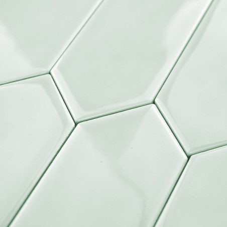 Ladrilhos hexagonais se encaixam perfeitamente, criando um padrão contínuo. Eles apresentam um acabamento verde menta brilhante,