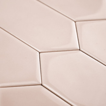 Sechseckige beige Fliesen greifen nahtlos ineinander und bilden ein geometrisches Muster. Die glatte, glänzende Oberfläche refle