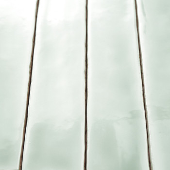 Los azulejos de color verde pálido brillante se encuentran en filas verticales, separadas por líneas finas y oscuras de lechada,