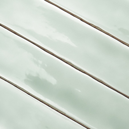 Les carreaux rectangulaires vert clair brillants sont alignés avec des lignes de coulis étroites et plus foncées, créant une app