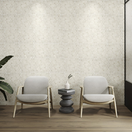 Elegant hexagonal stone tiles form a textured wall, illuminated by spotlights, behind two chairs and a table.