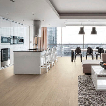 Een ruime, moderne keuken-eetkamer is voorzien van strakke witte kasten en een eiland, omgeven door barkrukken, een zachte bank 