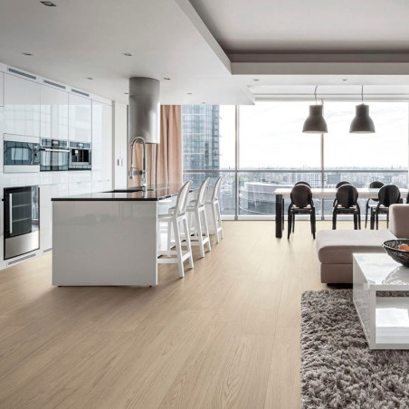 Een ruime, moderne keuken-eetkamer is voorzien van strakke witte kasten en een eiland, omgeven door barkrukken, een zachte bank 