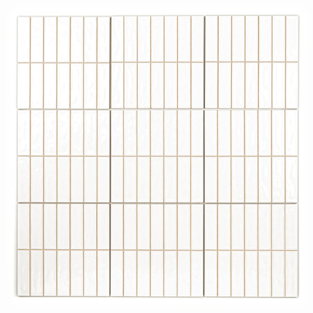 Les carreaux blancs rectangulaires s'alignent selon un motif de grille, bordé de fines lignes de coulis beiges. la surface est l