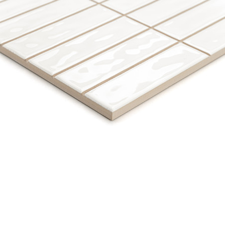Les carreaux rectangulaires blancs brillants sont posés en quinconce, créant un motif géométrique moderne sur un fond neutre.