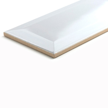A rectangular ceramic tile rests on a white surface, displaying a glossy finish with beveled edges, reflecting soft lighting.