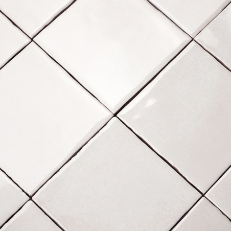 Los azulejos de cerámica cuadrados se alinean en una cuadrícula, creando un patrón sin costuras en una superficie plana, con lig