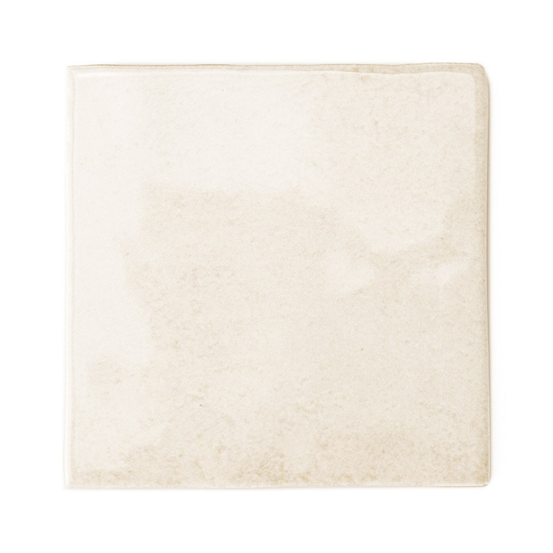 Un azulejo liso y cuadrado presenta un suave tono marfil con un sutil veteado, lo que sugiere una estética limpia y minimalista 